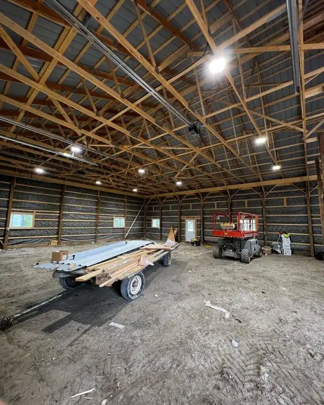 Warm LED high-bay lighting installed by Jayco in a timber-frame pole barn