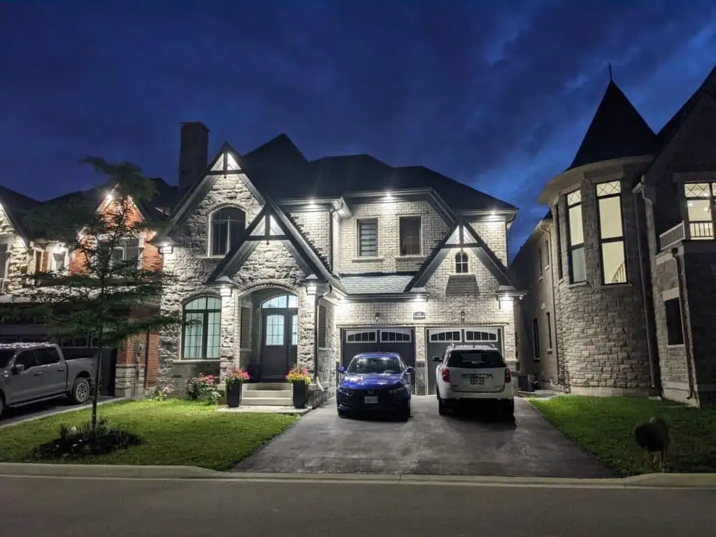 A stone home in the Greater Toronto Area lit at dusk with warm pot lights and soffit lighting installed by Jayco Electrical