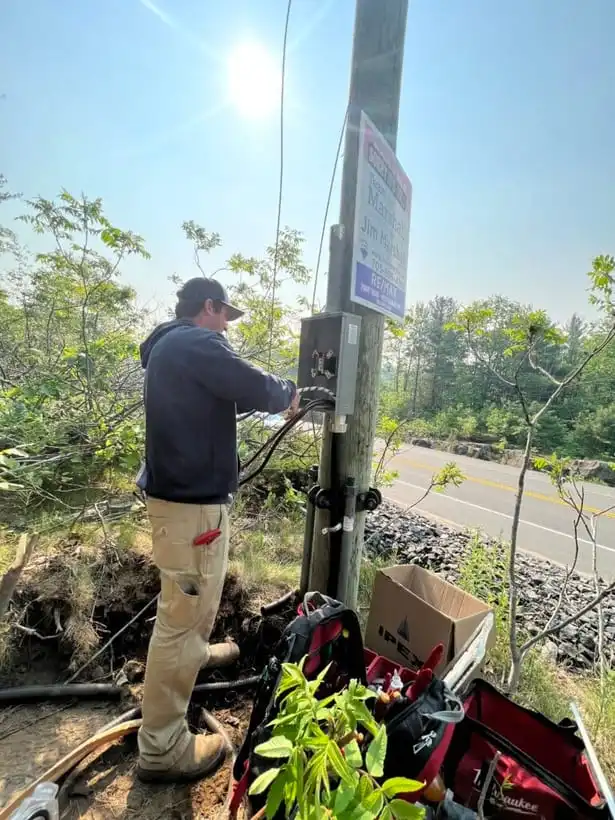 A Jayco Electrical technician working on a roadside service pole in rural cottage country north of the GTA